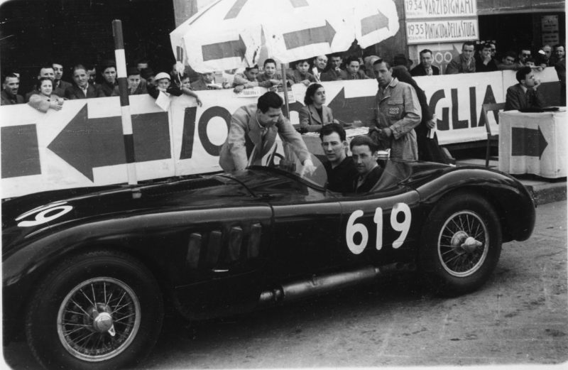 Sir Stirling Moss (behind the wheel) and Norman Dewis at the wheel of the Jaguar C-Type with the first disc brakes at the 1952 Mille Miglia